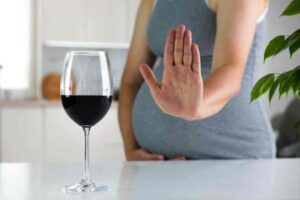 Pregnant Mother Holding Her Stomach with alcohol