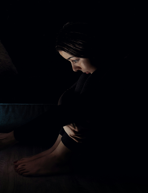 Person in dark room looking down