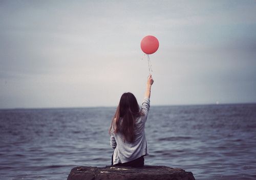 teen alone at beach with balloon