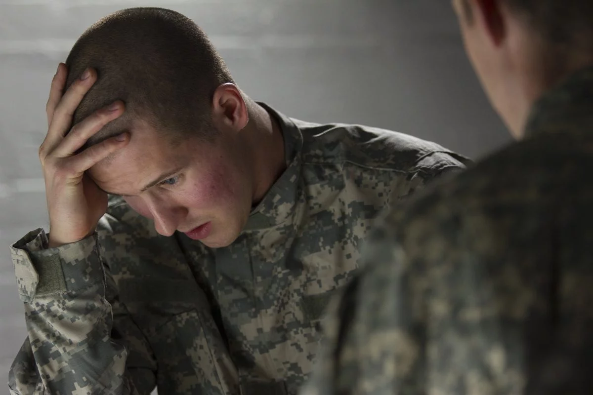 Emotional military man consoled by peer